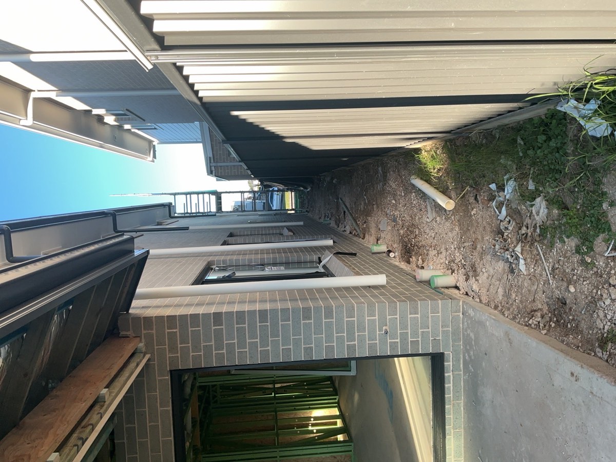 Downpipes installed to first floor only, recorded at a lock-up inspection in Austral