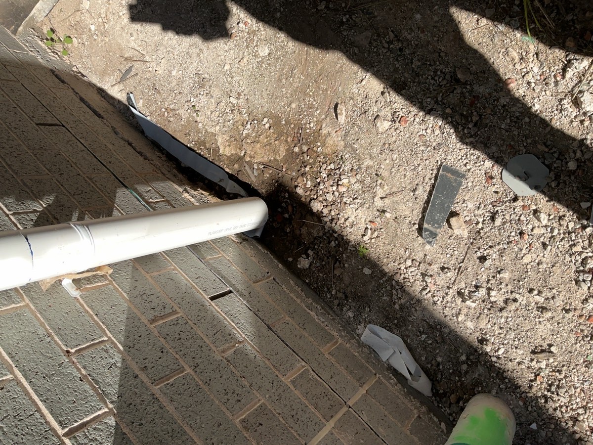 Downpipe not installed to ground floor, recorded at a fixing stage inspection in Austral